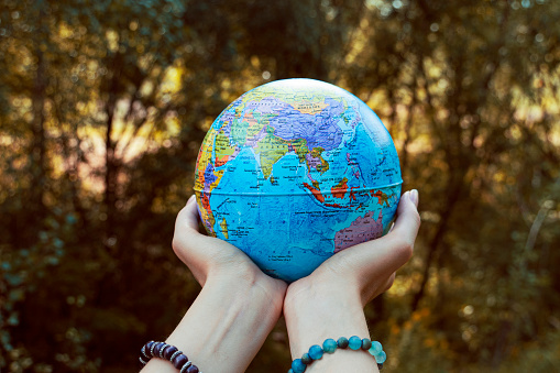 The planet is in the hands of people. Save our planet. Female hands holds globe.