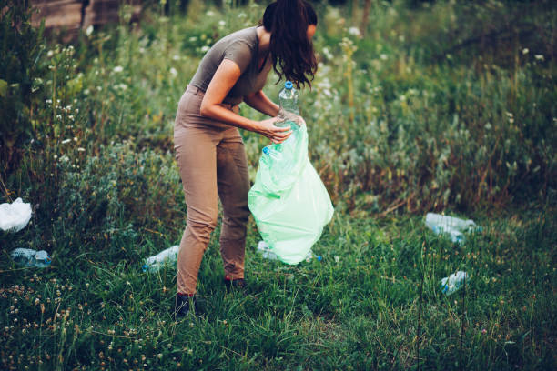 istock Female volunteer picks up trash in park 1165406496