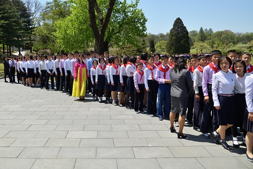 North Korea, Pyongyang - May 1, 2019: A group of North Korean peoples adults and children visit the Mangyongdae village, birthplace of Kim Il Sung.  DPRK