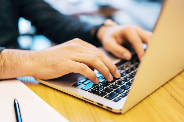 istock Sideview of man doing paperwork with laptop 1165406659