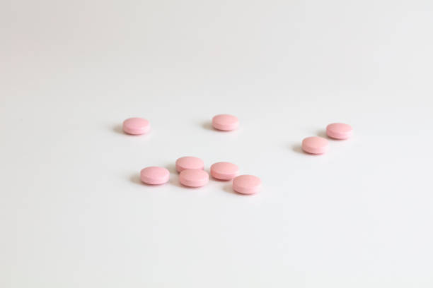 rosa pillen isoliert auf weiß zeigt die wichtige behandlung - pink pill stock-fotos und bilder