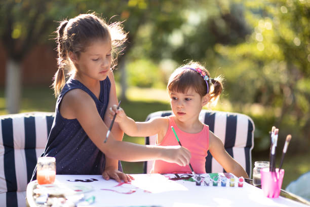 istock Children Drawing Picture Outdoors in Summer 1165410867