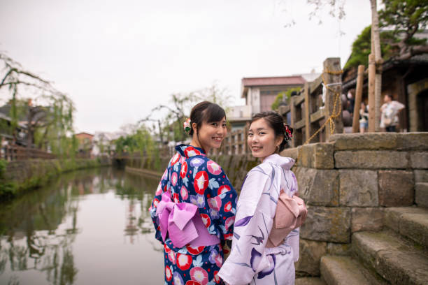 istock Young women in yukata looking over shoulder at river side 1165416231