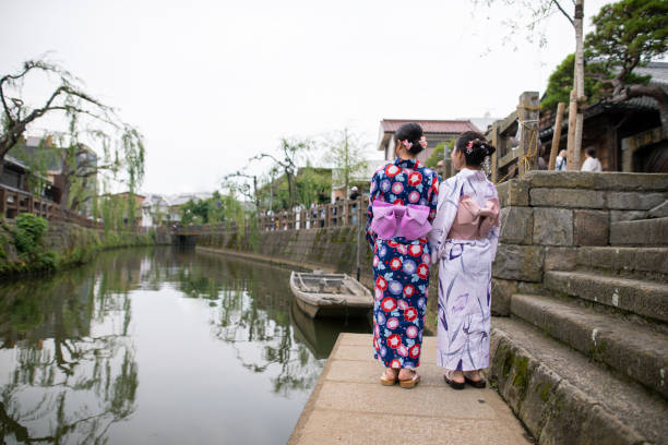 istock Young women in yukata looking at view from river side 1165416288