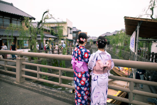 istock Young women in yukata looking at view from bridge 1165416298