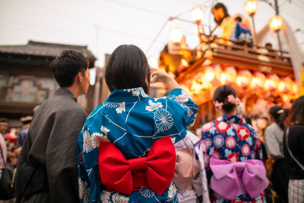 young couple in yukata taking photos of matsuri parade - obi sash fotos imagens e fotografias de stock