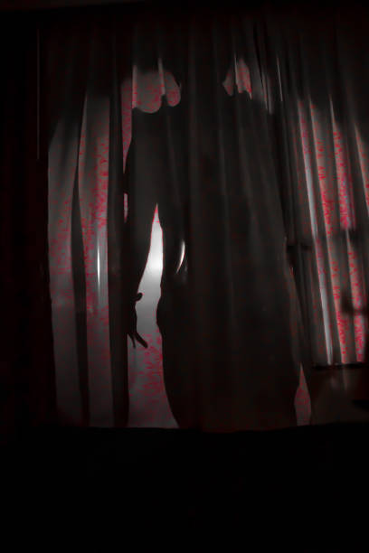 istock shadow of a person behind a curtain 1165416389