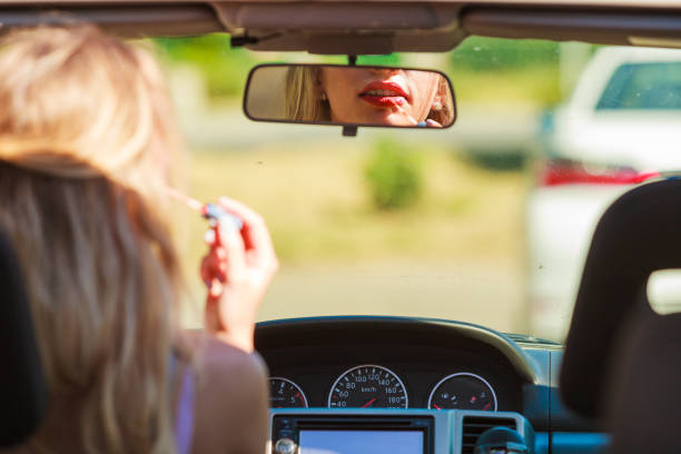 istock Girl apply make up while driving car. 1165416511