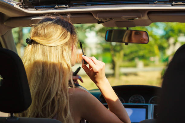 istock Girl apply make up while driving car. 1165416517