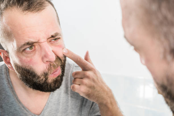 istock Man looking at wrinkles on his face 1165418741