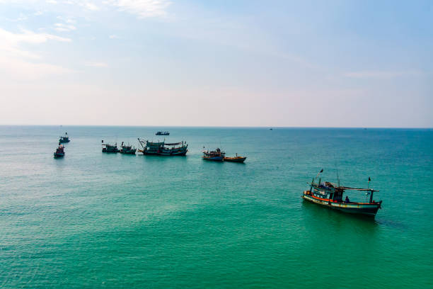 Small wooden fishing boats off Ochheuteal Beach. Sihanoukville, Cambodia. Small wooden fishing boats off Ochheuteal Beach. kep stock pictures, royalty-free photos & images