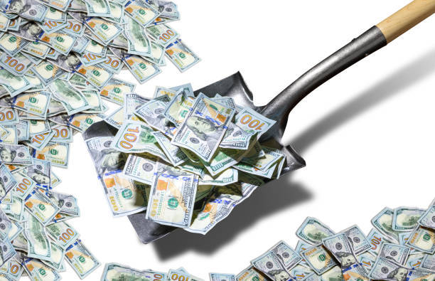 Shovel lifts American dollar bills. Isolated on white background stock photo