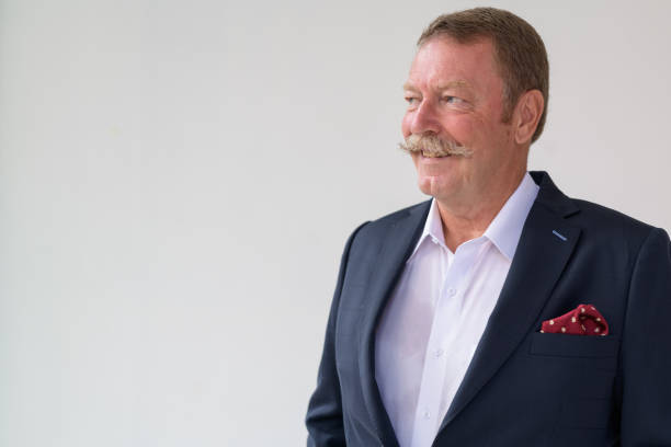 istock Happy senior businessman smiling while thinking indoors 1165425573