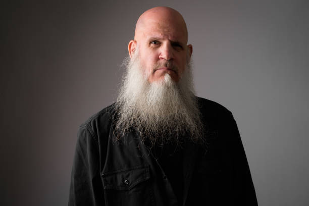 istock Face of mature bald man with long gray beard looking at camera 1165426190