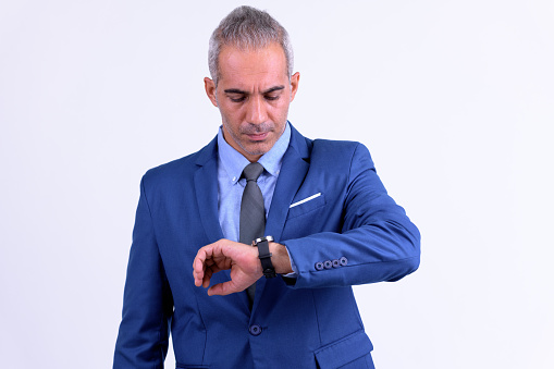 Studio shot of handsome Persian businessman with suit against white background