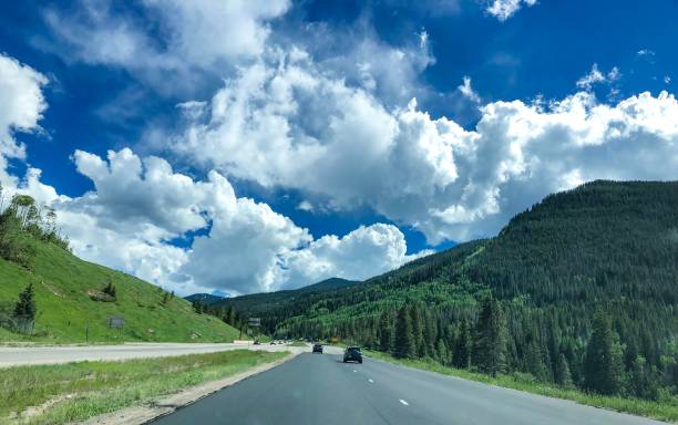 istock cars driving past forest mountains 1165427459