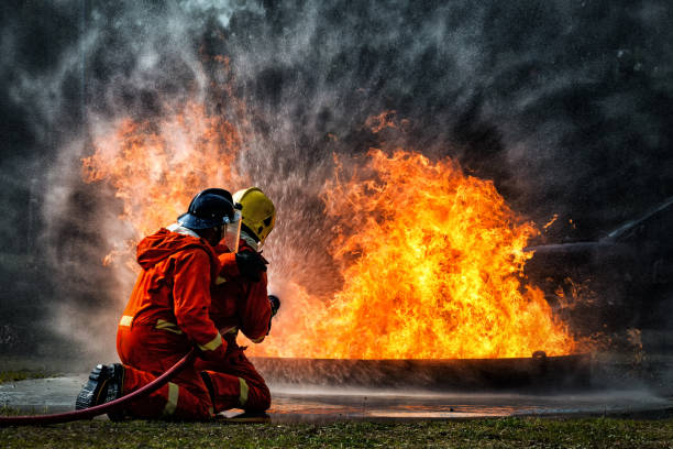 istock firefighter training., fireman using water and extinguisher to fighting with fire flame in an emergency situation., under danger situation all firemen wearing fire fighter suit for safety. 1165428587
