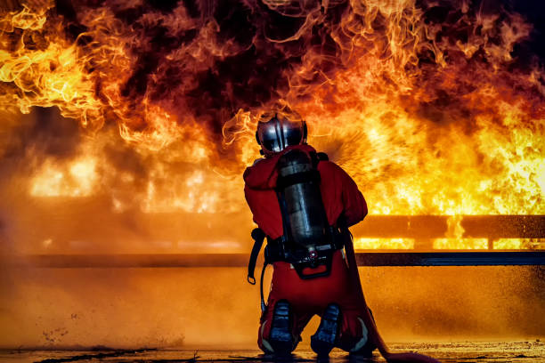 istock Firefighter training., fireman using water and extinguisher to fighting with fire flame in an emergency situation., under danger situation firemen wearing fire fighter suit for safety. 1165428589