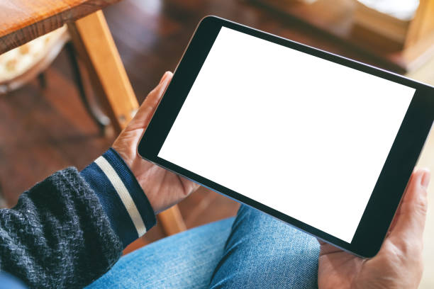 istock a woman sitting and holding black tablet with blank white desktop screen 1165431944