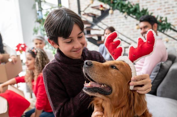 istock Happy boy celebrating Christmas and playing with his dog 1165432332