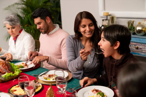 istock Mother feeding her son while having dinner on Christmas Eve 1165436134