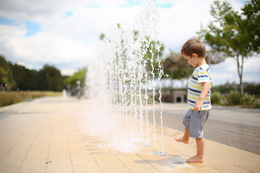 Small boy playing in a water feature at a Sydney park in Australia