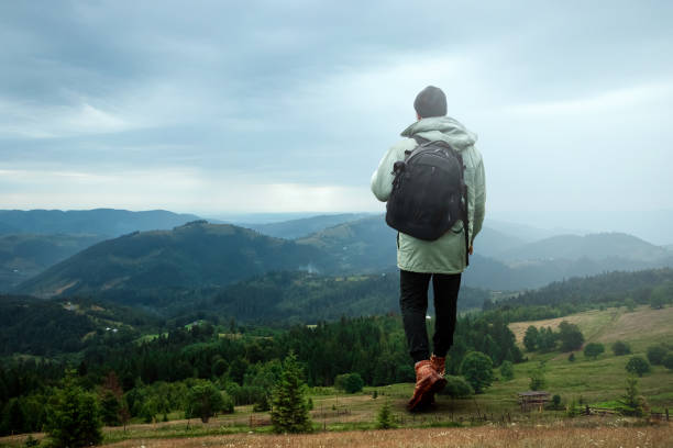 istock Creative background, A man is giant, a man is a tourist, he walks through a mountainous area with a backpack. The concept of Guliver, active tourism, recreation, the Carpathians. Mixed media 1165444320