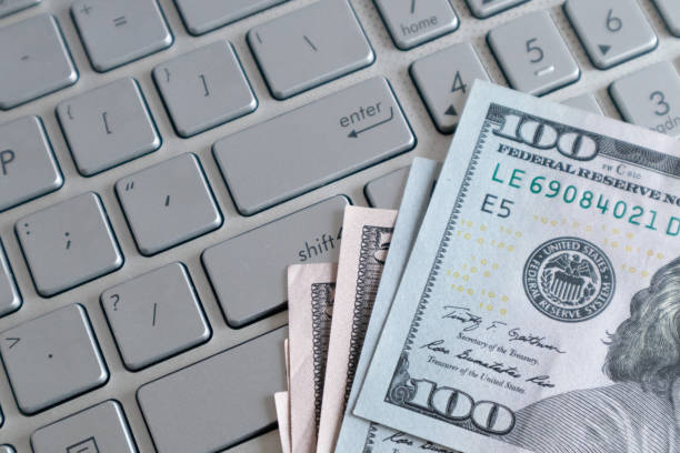 Dollar banknote on a laptop. Earned money by working from laptop at home.Freelance work making money concept