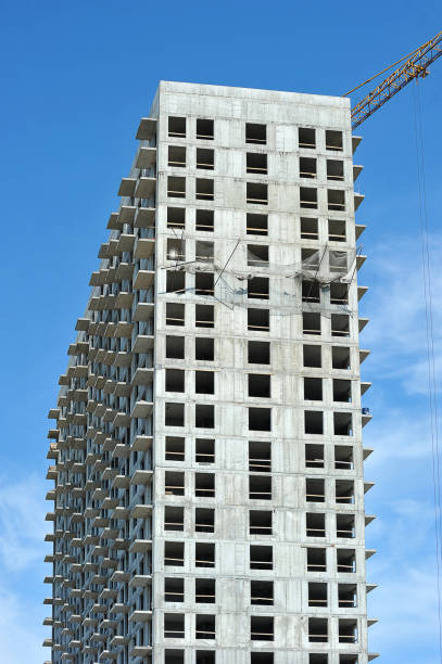 istock empty concrete box of high-rise building and construction crane 1165450326