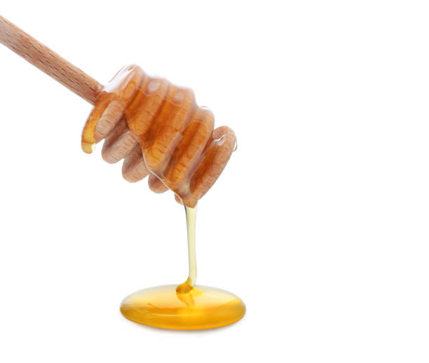 istock Honey is pouring from wooden dipper 1165450514