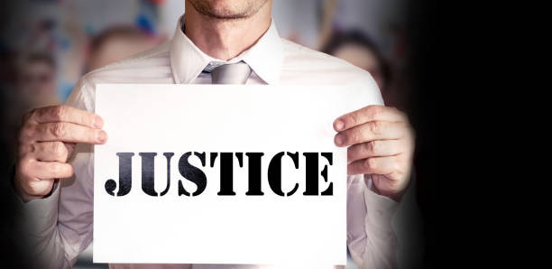 istock Man having a banner with the word Justice ,protest concept 1165452044