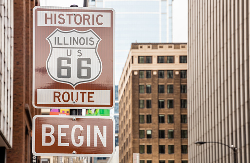 Route 66 Illinois Begin road sign at Chicago city downtown. Buildings facade background. Route 66, mother road, the classic historic roadtrip in USA