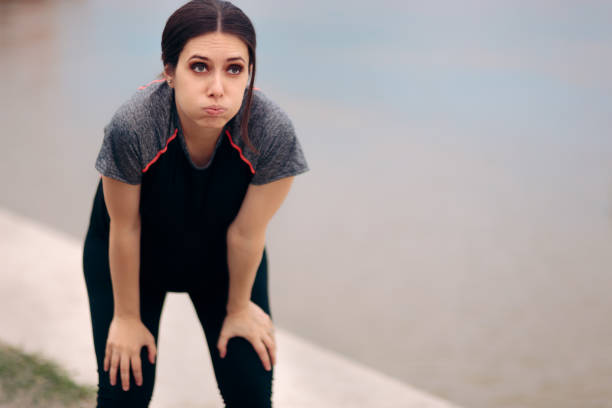 mujer embarazada cansada tomando un descanso después de trotar - furioso fotografías e imágenes de stock