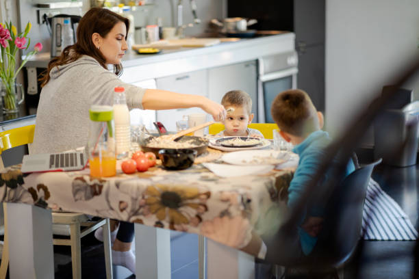 istock Mother feeding younger having his mouth ful 1165459569