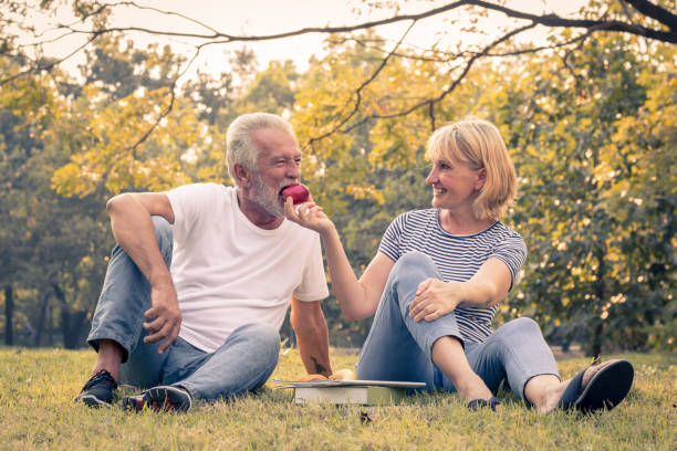 istock Couples senior give apples to each other together happily. 1165459601