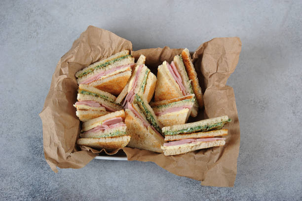 istock A dish of white bread sandwiches. Sandwich stuffed with ham, cheese and scrambled eggs with spinach. View from above. 1165460414