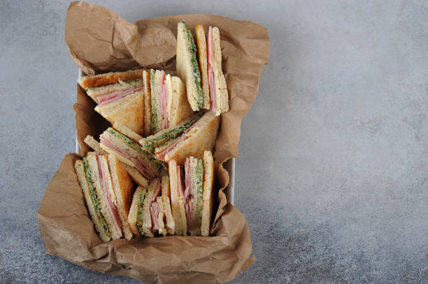 istock A dish of white bread sandwiches. Sandwich stuffed with ham, cheese and scrambled eggs with spinach. View from above. Free space to place text. 1165460426