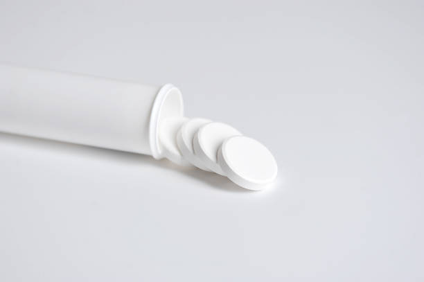 istock White tablets are poured out of a white plastic bottle. Tablets for dissolving in water. Space for text placement. White background. 1165461461