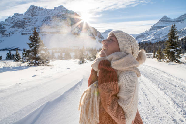Portrait of girl in winter contemplating nature and enjoying snowy landscape Young woman standing in snowy landscape in Canada relaxing in winter vacations exhaling stock pictures, royalty-free photos & images