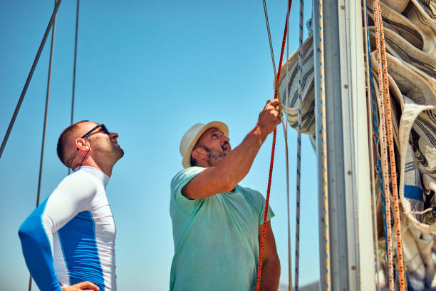 istock Sailor packing / unpacking main sail wing on the boat. 1165463772