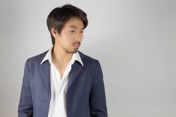 istock Portrait Man in Navy Blue Suit Looking Below 1165463990
