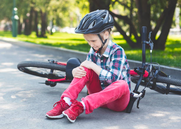 crying girl is sitting next to her bike - child bicycle cycling danger imagens e fotografias de stock