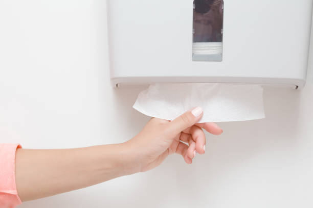 Woman hand taking white paper from holder on wall. Hygiene concept. Closeup. Woman hand taking white paper from holder on wall. Hygiene concept. Closeup. change dispenser stock pictures, royalty-free photos & images