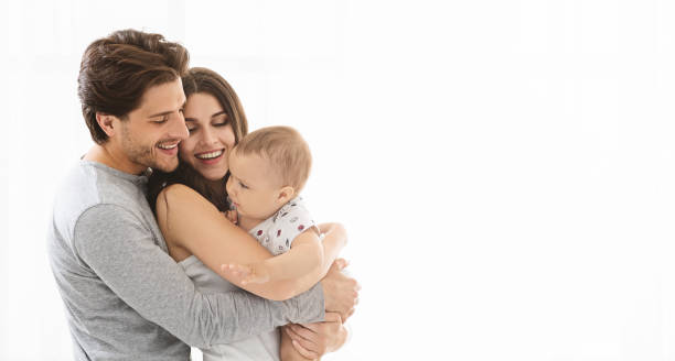istock Adorable millennial family embracing at home, empty space 1165465601