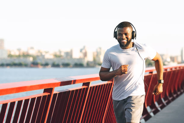 istock Happy african american man jogging along the bridge 1165465871