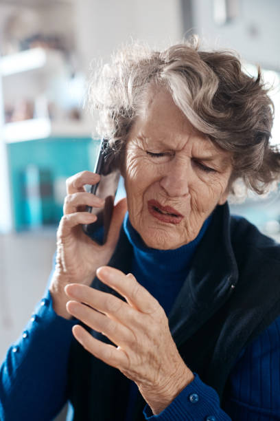 istock Senior woman grimaces, having problem hearing sound on mobile phone 1165466723