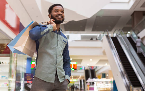 istock Handsome african man with purchases waiting for girlfriend 1165467792