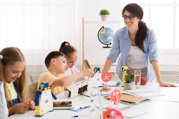 istock Children building robot vehicle with teacher's help 1165467981