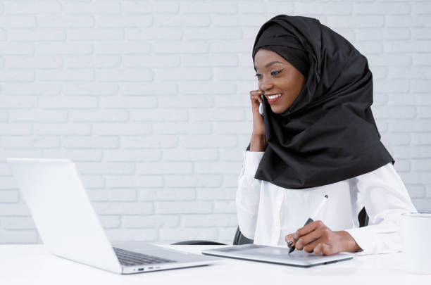 istock Muslim woman working in office, talking by phone. 1165468028