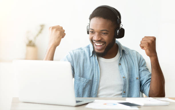 istock Black male freelancer celebrating successful completing online interview 1165469423